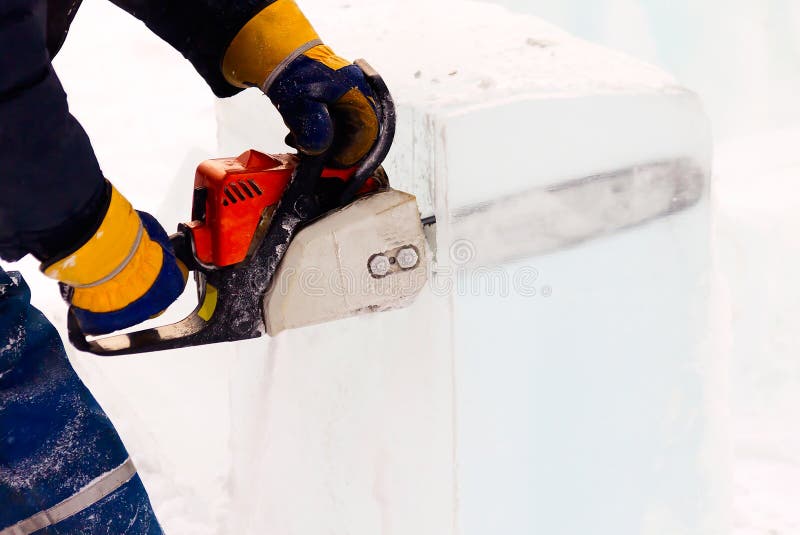 A Worker with a Chainsaw in His Hands Saws an Ice Cube. Stock Photo Image of skill, mall
