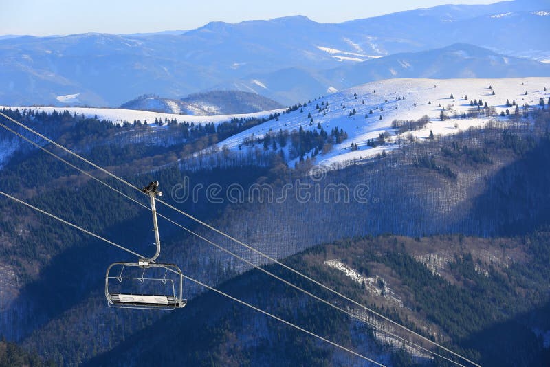 Chair lift on mountains background