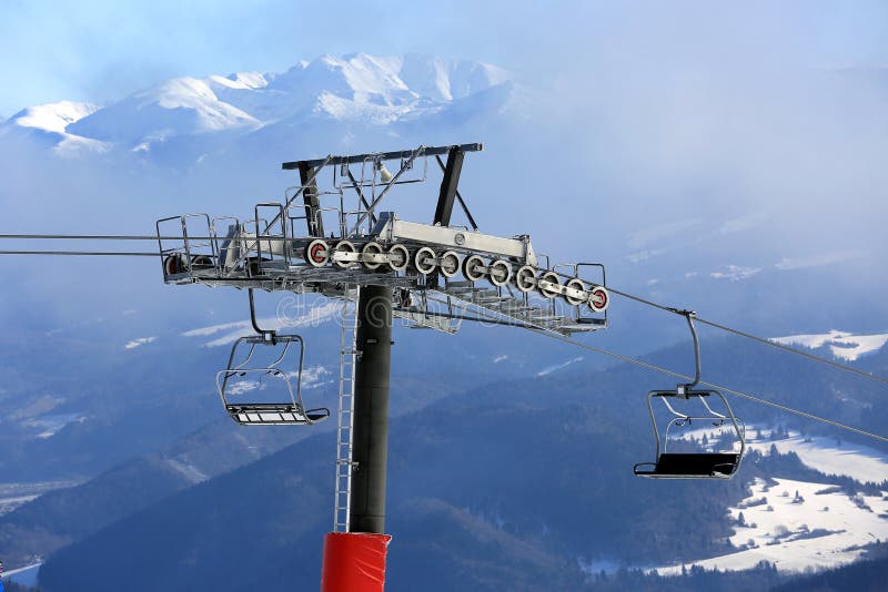 Chairlift on winter ski resort against mountain Background