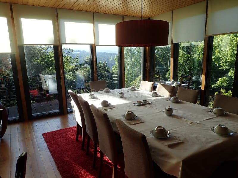 Chairs and Cups and Dining Room Table with Red Carpet Stock Photo