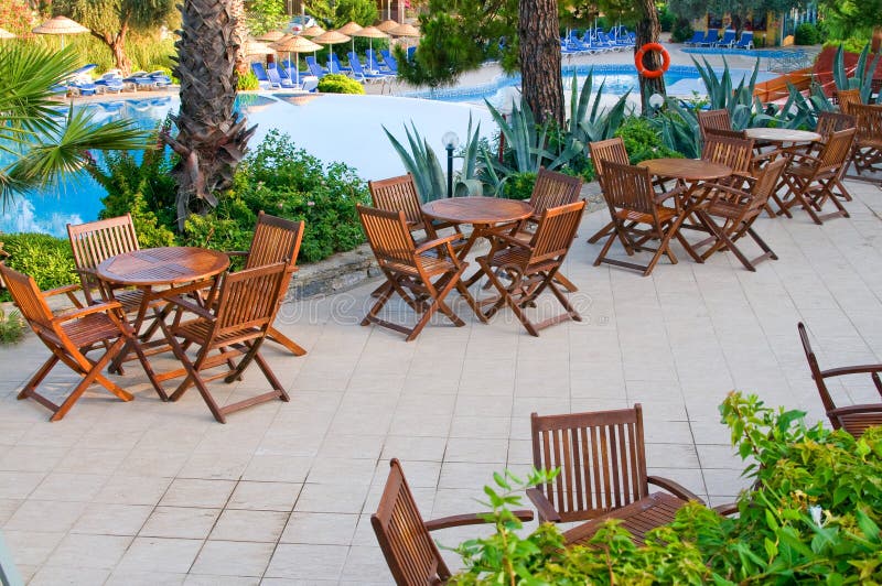 Chairs, tables and swimming pool early morning.