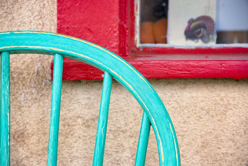 Turquoise colored antique chair sitting in front of a red window frame on Canyon Road in Santa Fe, NM. Turquoise colored antique chair sitting in front of a red window frame on Canyon Road in Santa Fe, NM
