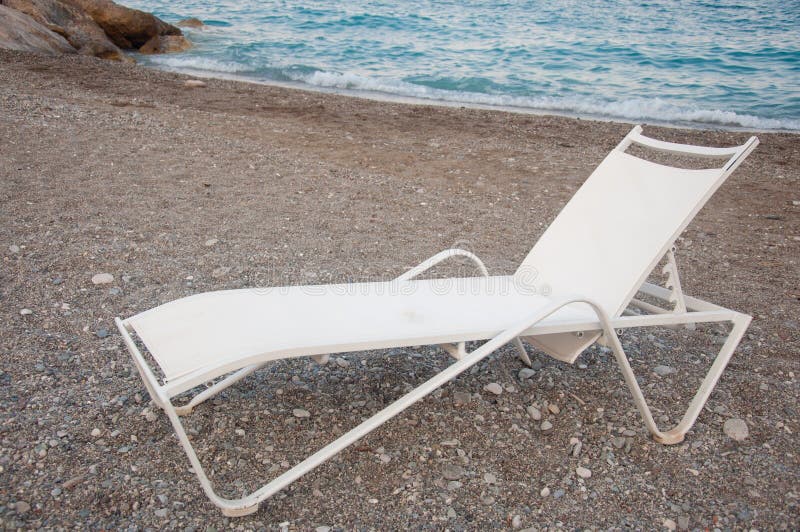 Chaise longue sulla spiaggia. Chaise longue bianche sulla spiaggia del mare
