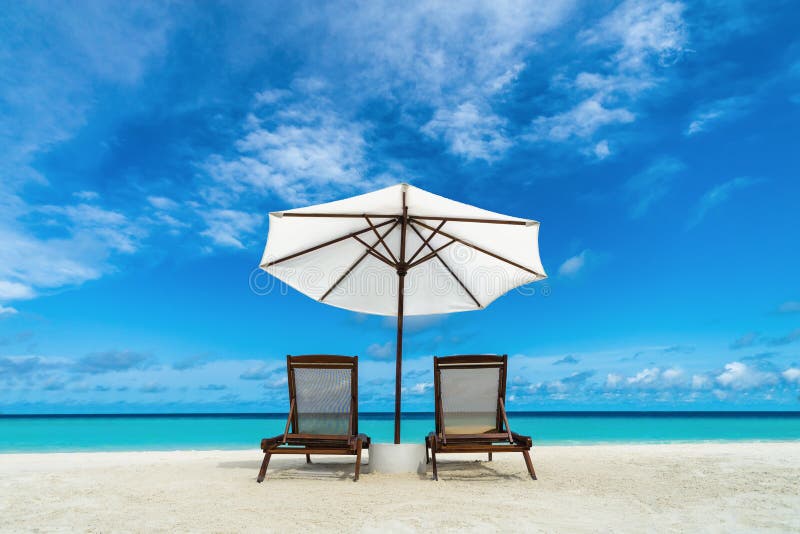 Chaise-lounge ed ombrello della spiaggia sulla spiaggia di sabbia Concetto per resto, rilassamento, feste, stazione termale, loca immagini stock libere da diritti