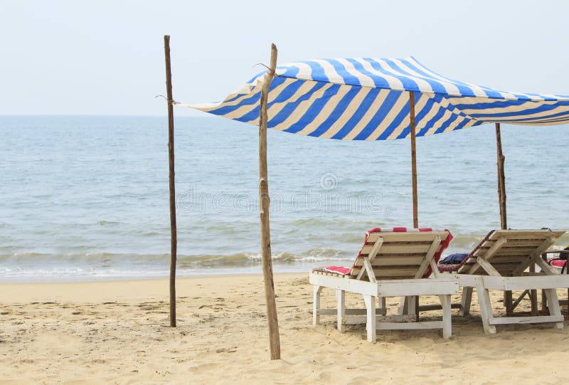 Chaise Lounges Under a Canopy on the Beach Near the Ocean Stock Image
