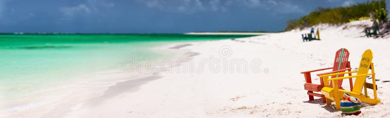 Chaises colorées sur la plage des Caraïbes images stock Chaises colorées sur la plage des Caraïbes images stock