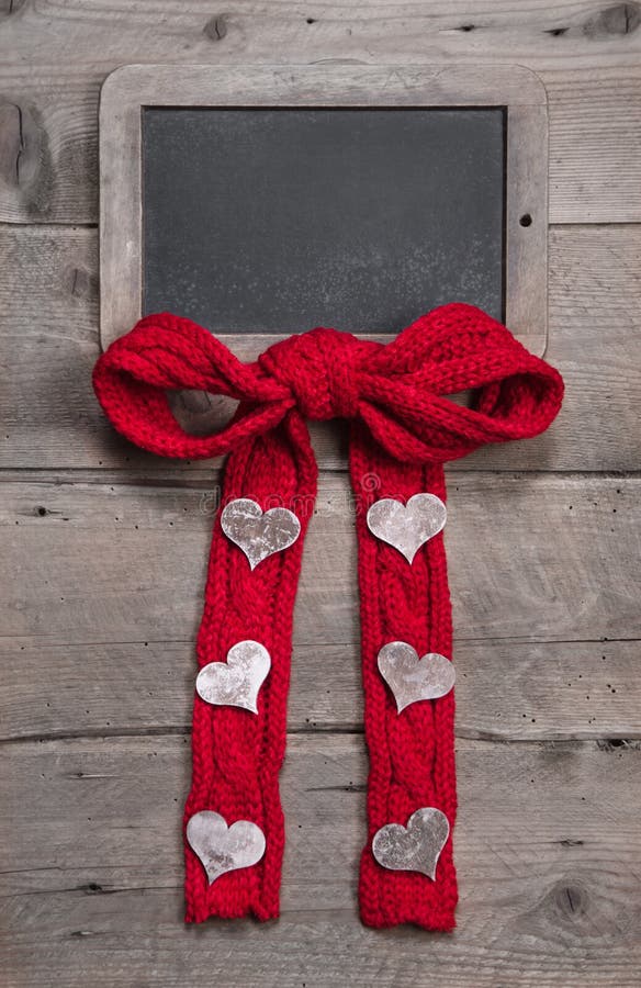 Chalk board for message with red knitted bow and hearts on grey wooden background for valentine's day, mother's day, birthday or anniversary