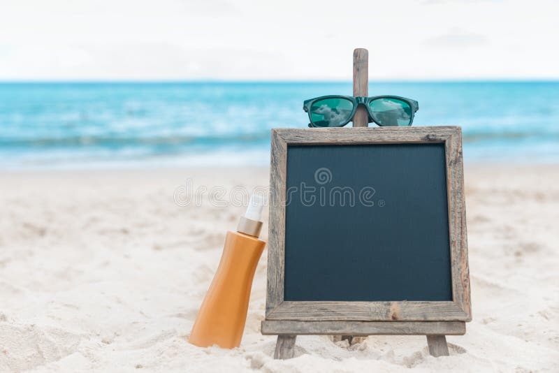 Chalk Board With Sunscreen Cream In The Sand On The Beach Tropic