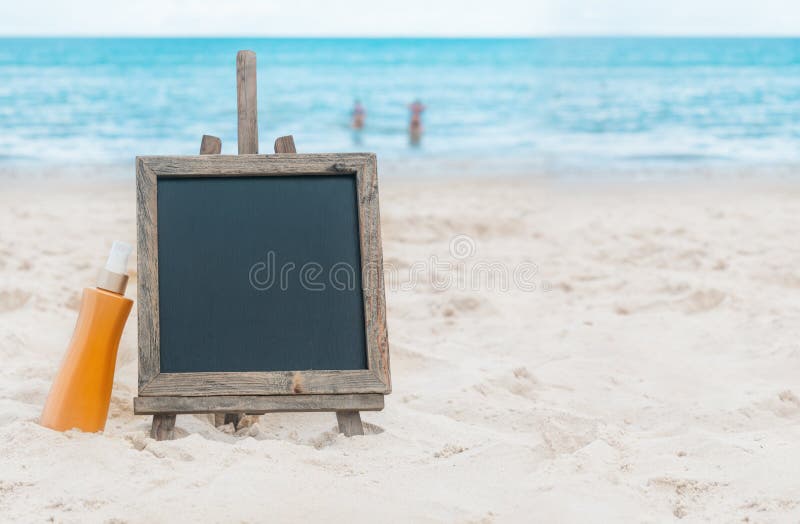 Chalk board sunscreen cream sand on beach tropic.