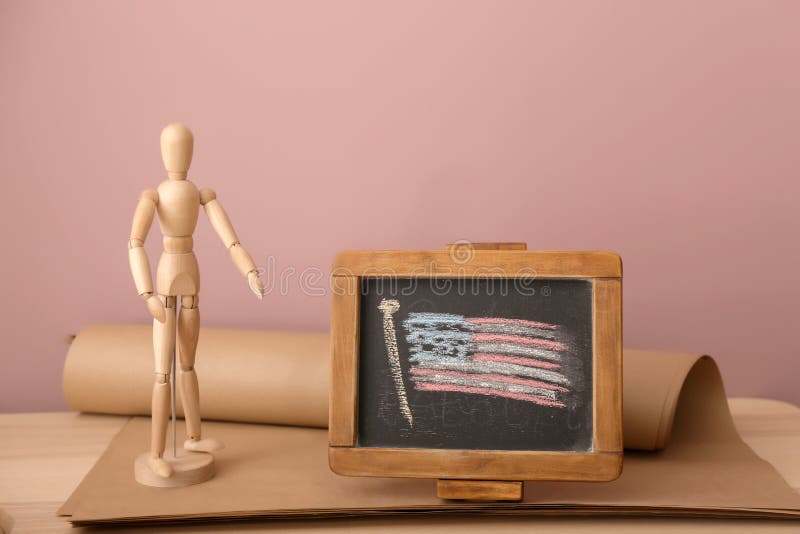 Chalkboard with drawing of American national flag and small mannequin on wooden table stock image Chalkboard with drawing of American national flag and small mannequin on wooden table stock image