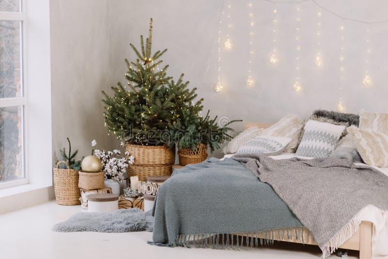 Chambre décorée par Noël intérieure avec l'arbre confortable de lit, de sapin de Noël et la boîte sur le sol, l'espace de copie M images stock