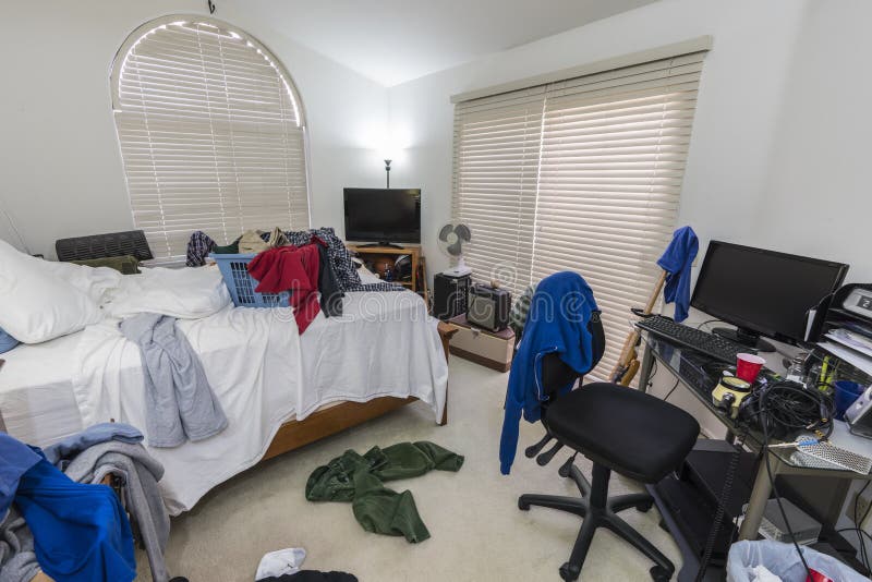 Cluttered, messy teenage boys bedroom with piles of clothes, music and sports equipment. Cluttered, messy teenage boys bedroom with piles of clothes, music and sports equipment.