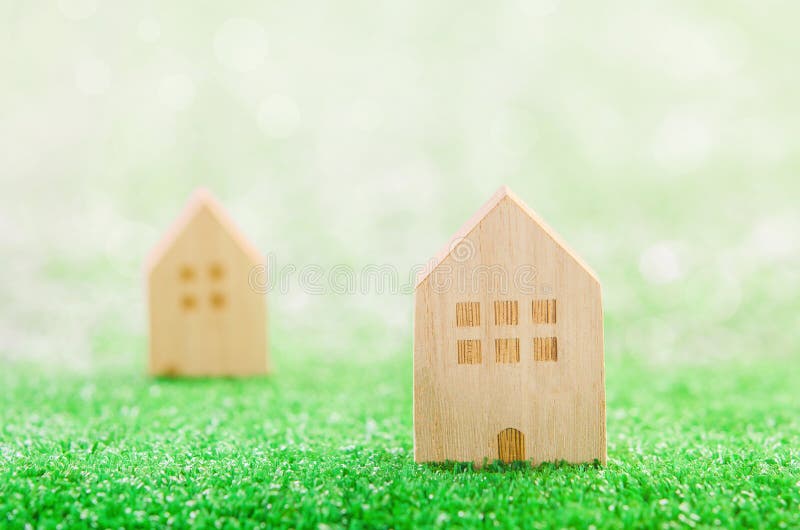 Miniatures de maisons en bois sur un champ vert photos stock