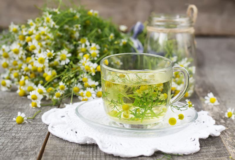 Chamomile flowers in a glass jar on a wooden background