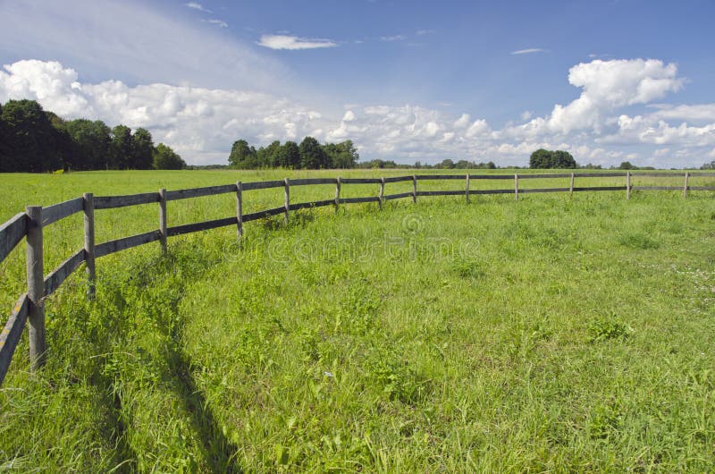 Champ rural de terres cultivables de paysage avec la barrière en bois image stock Champ rural de terres cultivables de paysage avec la barrière en bois image stock