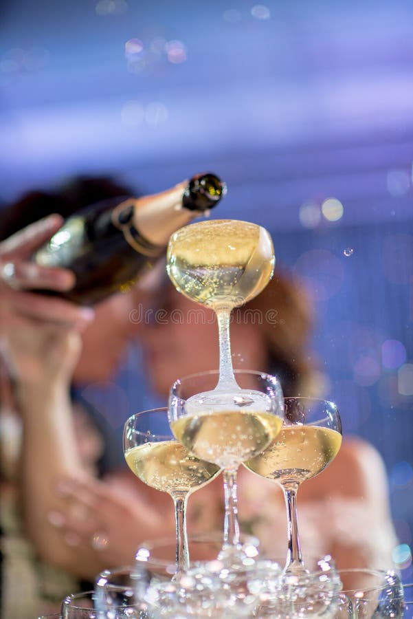 Champagne tower with couple in wedding party