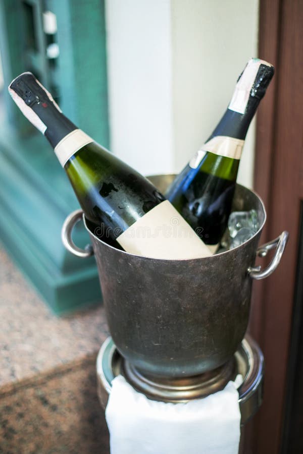 Champagne Bottle in Bucket with Ice and Glasses of Champagne Stock