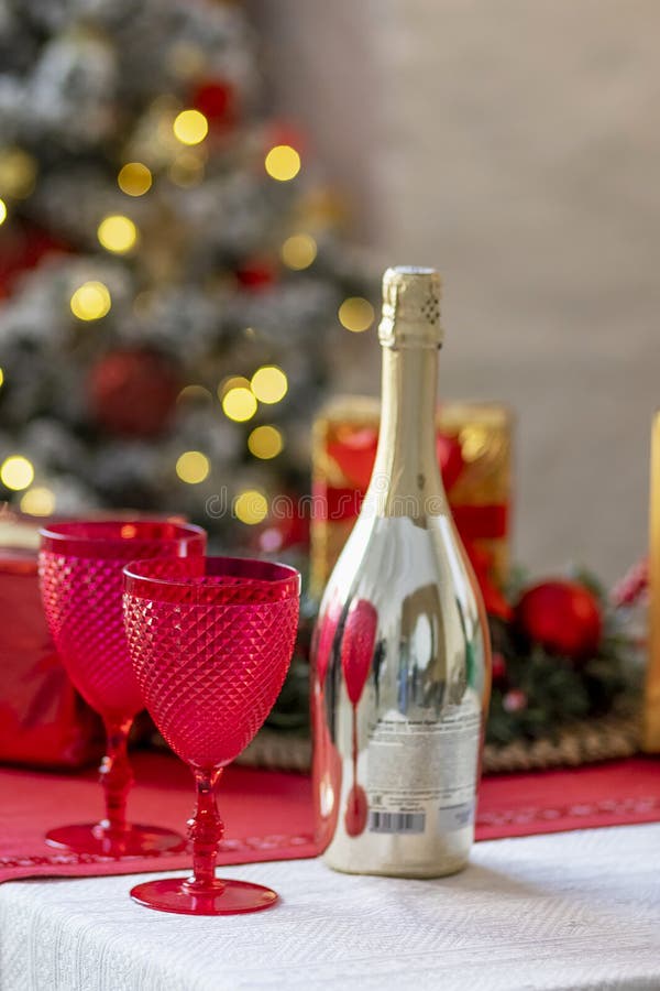 Champagne Bottles and Glasses on the Table Against the Backdrop of Christmas Decorations Stock