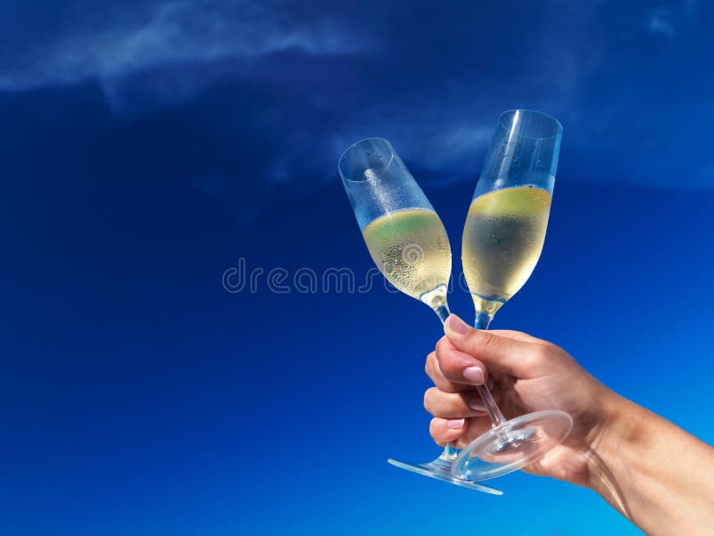 Šampaňské flétny proti modré obloze.