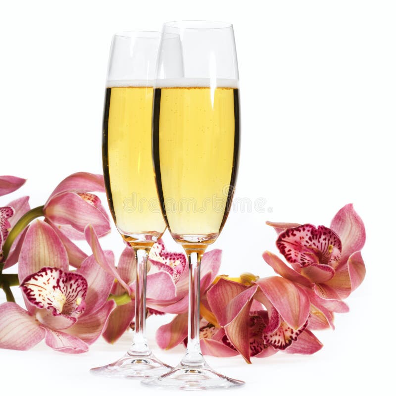 Šampaňské flétny a květy na bílém.