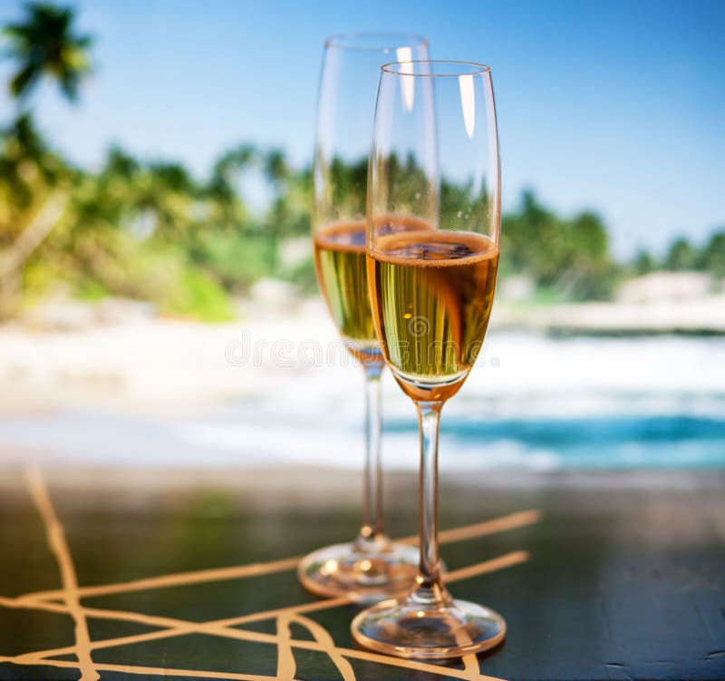 Champagne glasses on tropical beach - exotic New Year