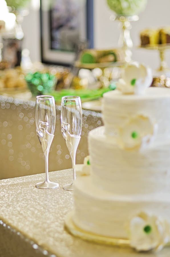 Two champagne flutes surrounded by wedding cake and desserts. Focus on glasses. Two champagne flutes surrounded by wedding cake and desserts. Focus on glasses.