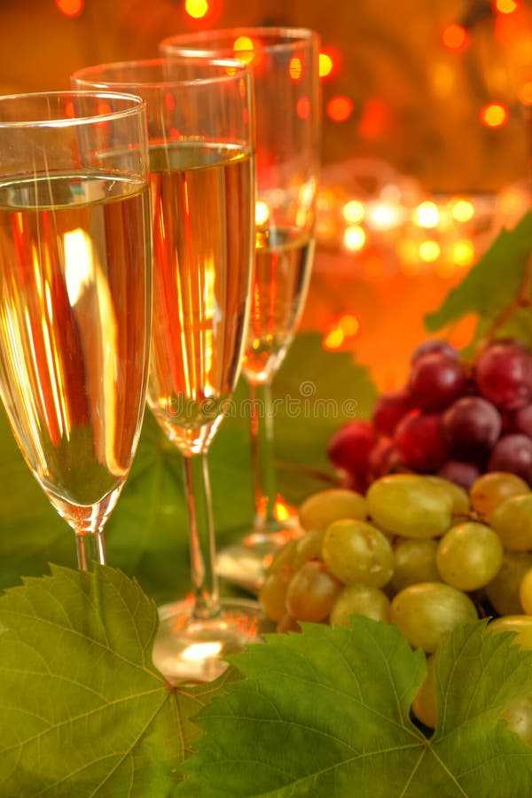 Champagne with grapes on gold background.