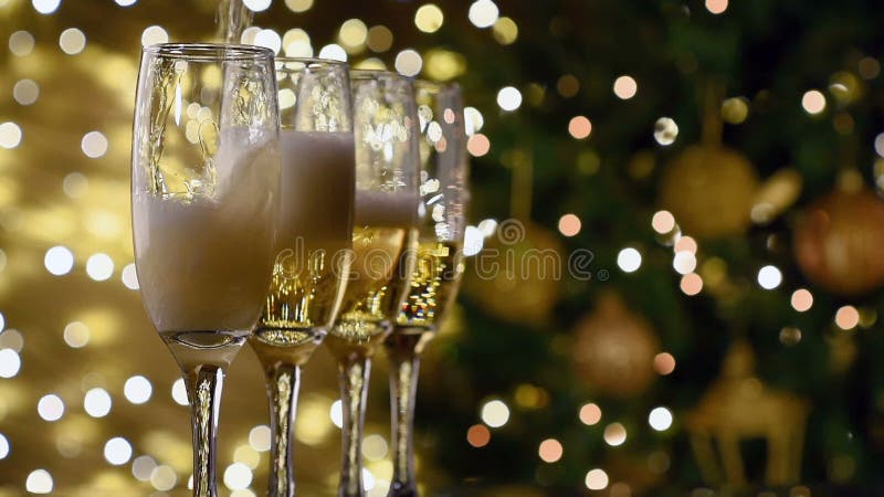 Champagne poured in flutes light background, new year christmas tree background