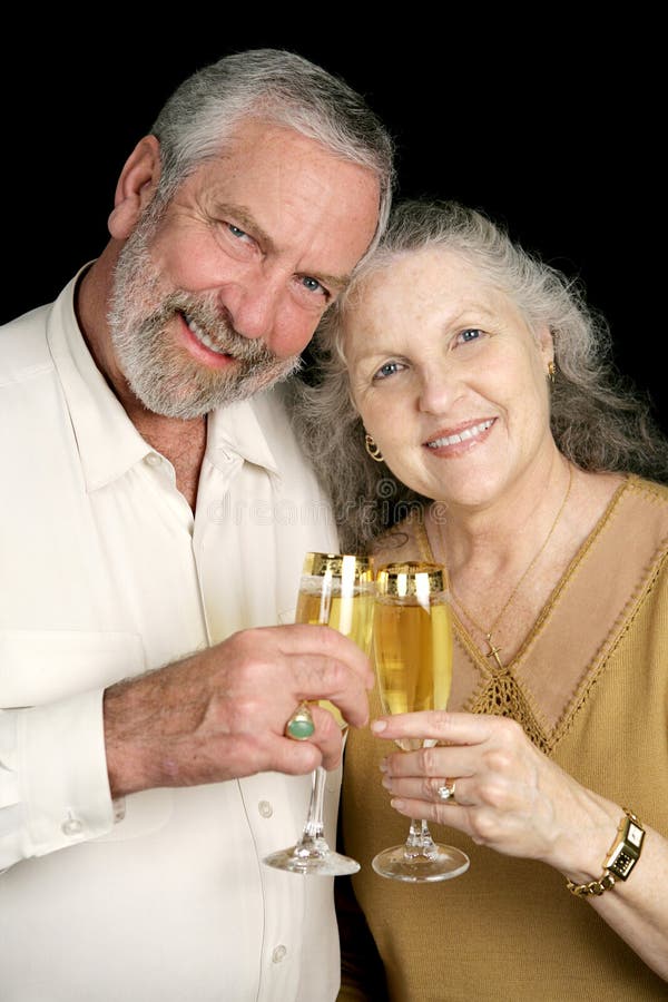 Good looking mature couple toasting the season with champagne. Black background. Good looking mature couple toasting the season with champagne. Black background.