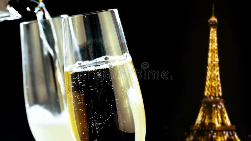 Champagneflöjter med guld- bubblor på guld- blänker gnistrandeEiffeltorn på svart nattbakgrund, feriejul