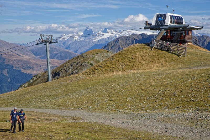 CHAMROUSSE, FRANCE, September 1, 2023 : Couple of climbers are nearly back to the cable-car after their trek in the mountain range. CHAMROUSSE, FRANCE, September 1, 2023 : Couple of climbers are nearly back to the cable-car after their trek in the mountain range