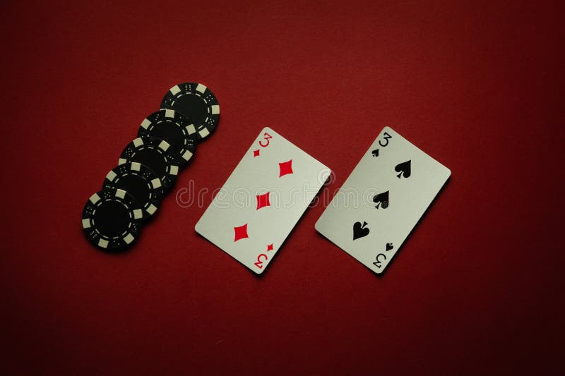 Luck in a poker card game with a winning one pair combination. Playing cards and chips are laid out in a club on a red table. Luck in a poker card game with a winning one pair combination. Playing cards and chips are laid out in a club on a red table.