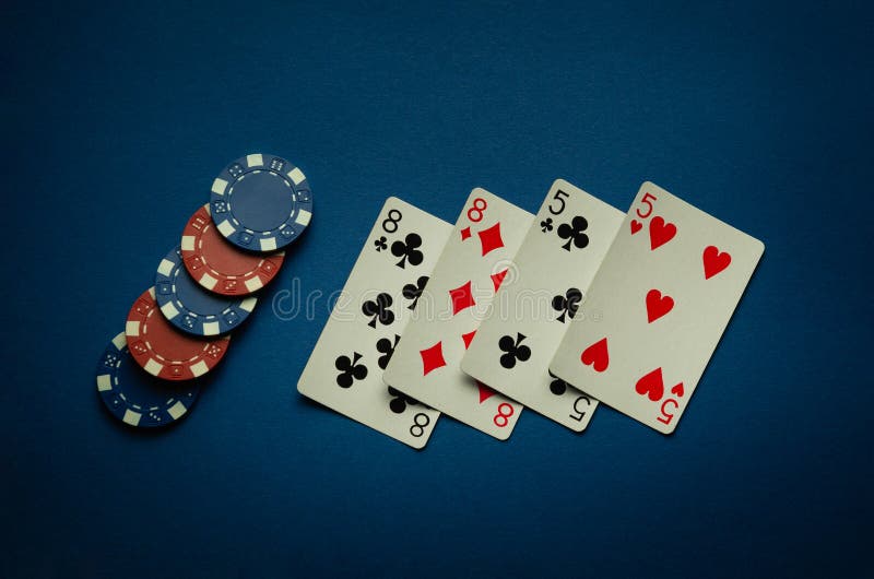 Luck in a casino game with a winning combination of two pairs. Playing cards and chips are laid out in a poker club on a blue table. Luck in a casino game with a winning combination of two pairs. Playing cards and chips are laid out in a poker club on a blue table.