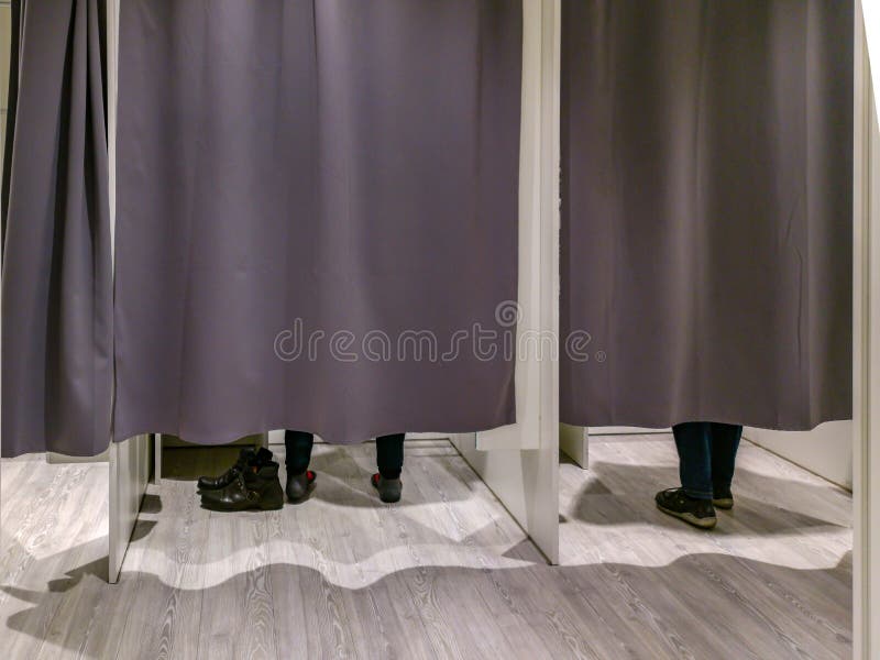 Changing Room with Closed Curtains and Feet of Two Customers Stock