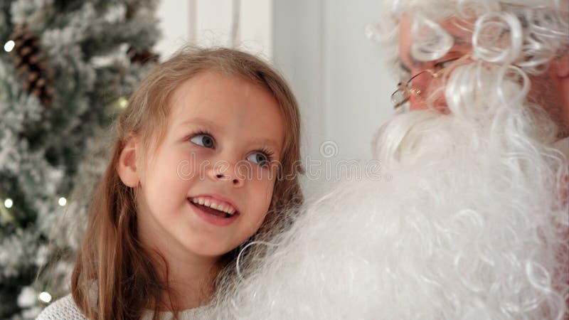 Chanson mignonne de Noël de chant de petite fille ainsi que Santa Claus photo stock Chanson mignonne de Noël de chant de petite fille ainsi que Santa Claus photo stock