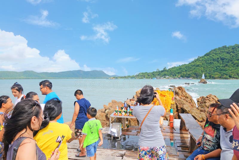 CHANTHABURI THAILAND-26 DE JULHO DE 2019: viajantes no caminho da ponte de madeira para Chedi Hua Laem pagoda na rocha do mar imagens de stock royalty free CHANTHABURI THAILAND-26 DE JULHO DE 2019: viajantes no caminho da ponte de madeira para Chedi Hua Laem pagoda na rocha do mar imagens de stock royalty free