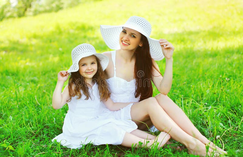 Chapeaux de paille blancs de port de sourire heureux d'enfant de mère et de fille photos stock Chapeaux de paille blancs de port de sourire heureux d'enfant de mère et de fille photos stock