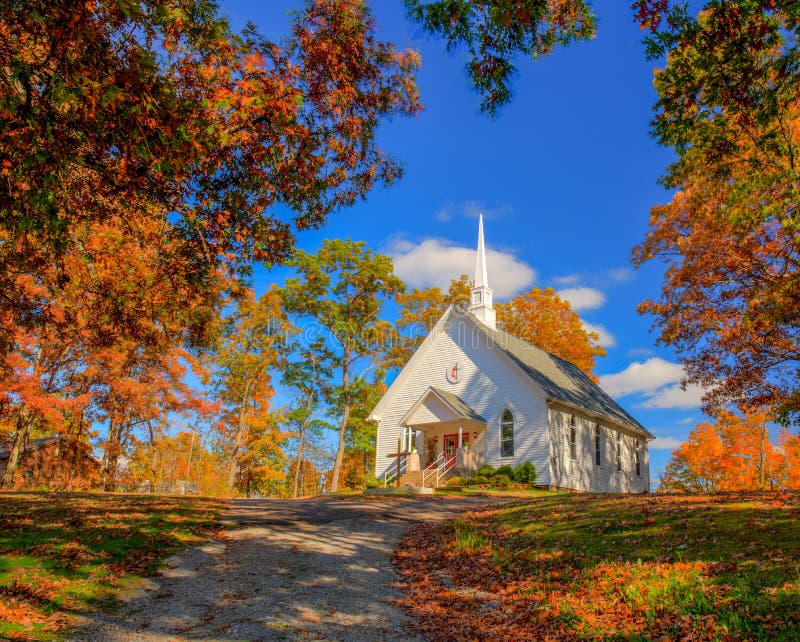 Chapel on a hill with fall colors and a blue sky