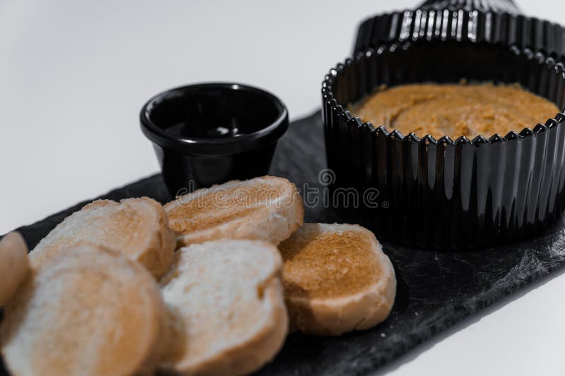 Chapotear con salsa y croutons sobre una tabla negra en un fondo blanco fotografía de archivo