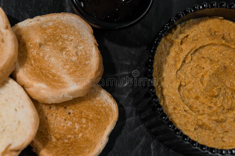 Chapotear con salsa y croutons sobre una tabla negra en un fondo blanco imagenes de archivo