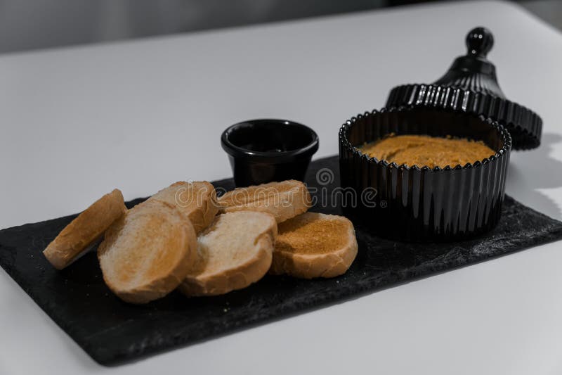 Chapotear con salsa y croutons sobre una tabla negra en un fondo blanco imagen de archivo libre de regalías