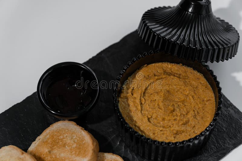 Chapotear con salsa y croutons sobre una tabla negra en un fondo blanco fotografía de archivo libre de regalías
