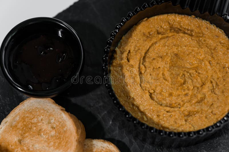 Chapotear con salsa y croutons sobre una tabla negra en un fondo blanco imagen de archivo