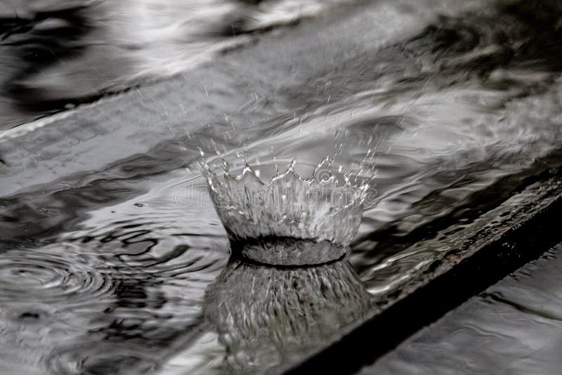 Chapoteo de la gota de lluvia en el piso de madera que despide y que forma una corona del agua imagenes de archivo Chapoteo de la gota de lluvia en el piso de madera que despide y que forma una corona del agua imagenes de archivo