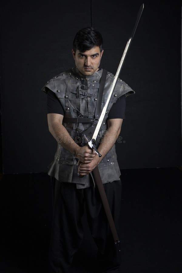 A handsome young man dressed as a medieval or fantasy warrior. This image would be suitable for a historical, fantasy or fantasy novel cover. A handsome young man dressed as a medieval or fantasy warrior. This image would be suitable for a historical, fantasy or fantasy novel cover.