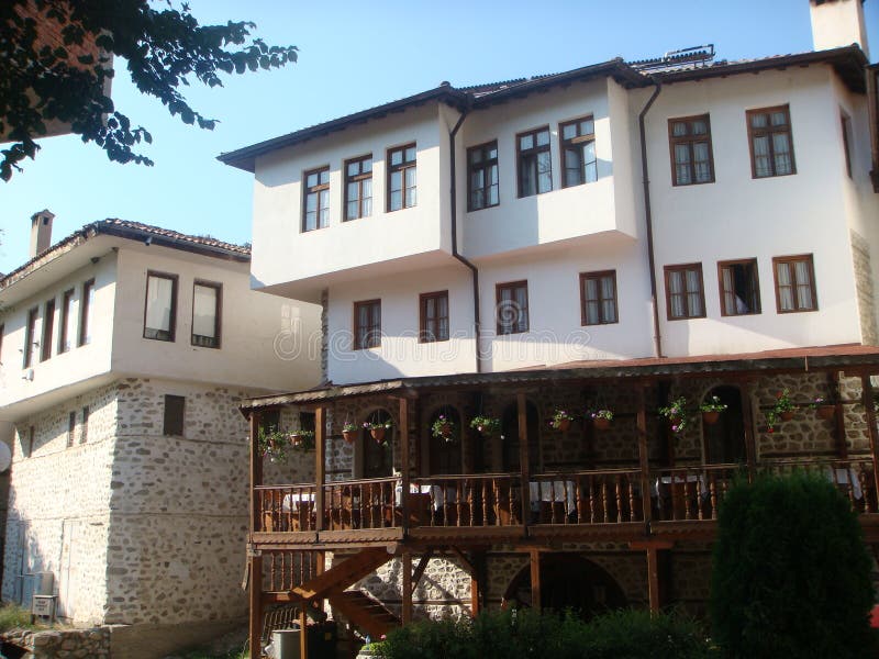 Charakteristische Häuser von Melnik in Bulgarien mit einer hölzernen Terrasse mit Tabellen lizenzfreie stockfotos Charakteristische Häuser von Melnik in Bulgarien mit einer hölzernen Terrasse mit Tabellen lizenzfreie stockfotos