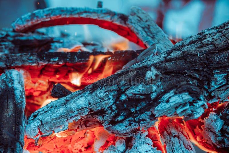 Charcoal and Logs Covered with Ash Burning with Bright Red Fire in