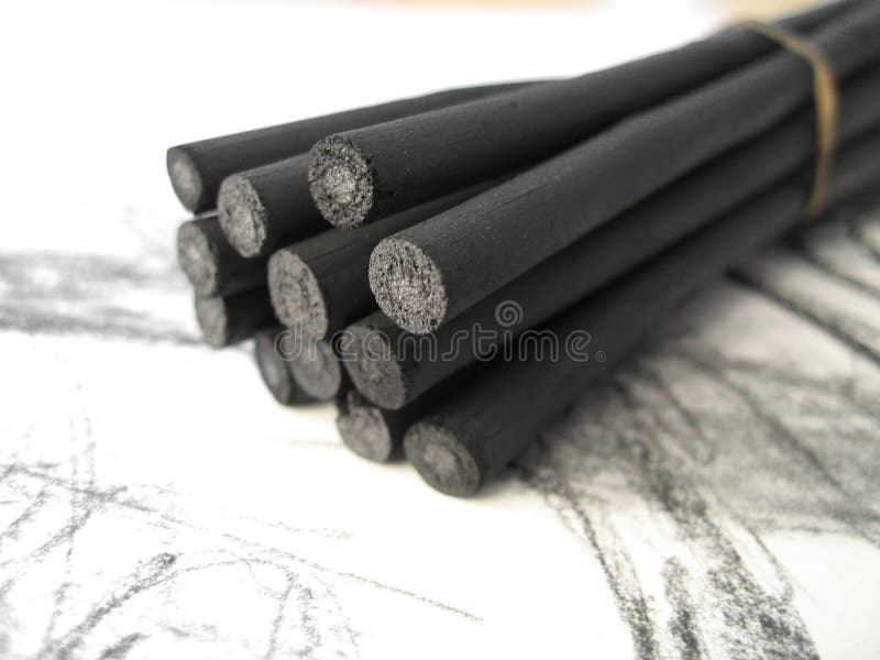 A bunch of artistsâ€™ charcoal sticks on a sketch pad. A bunch of artistsâ€™ charcoal sticks on a sketch pad