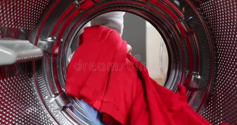 Chargement de la lessive à partir de la machine à laver. vue regardant de l'intérieur de la machine à laver pendant que la femme p banque de vidéos