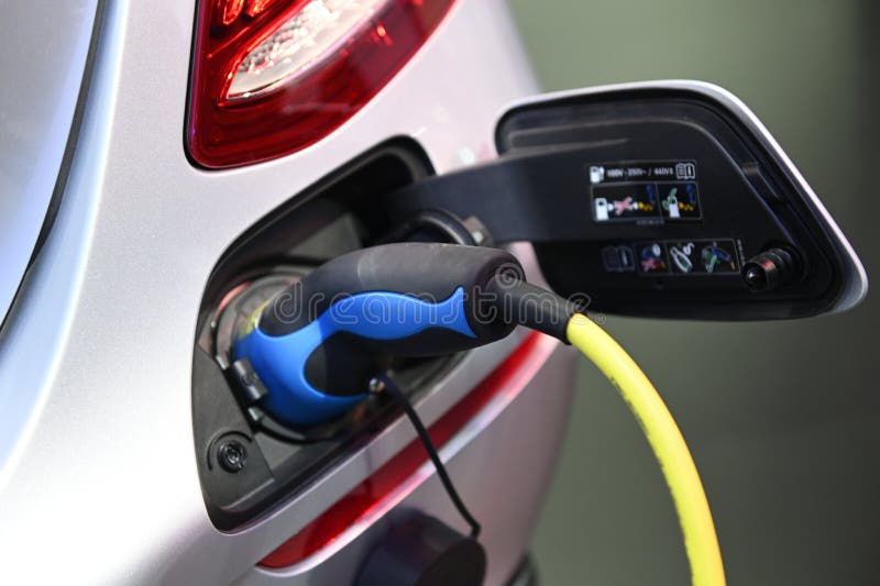 Charging an electric car with the power cable supply plugged in stock photo Charging an electric car with the power cable supply plugged in stock photo